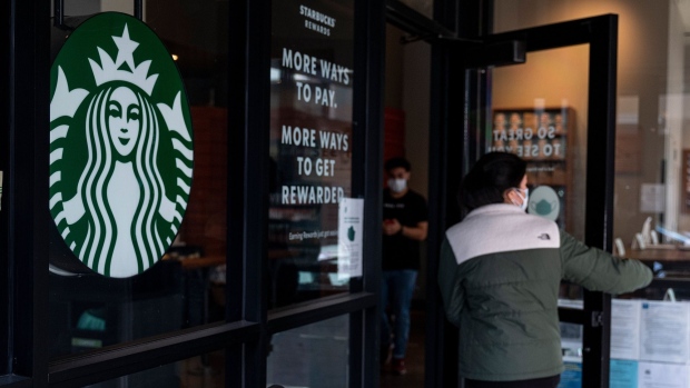A customer enters a Starbucks coffee shop. Photographer: David Paul Morris/Bloomberg