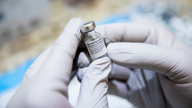 A healthcare worker holds a vial of the Pfizer-BioNTech Covid-19 vaccine. Photographer: Roger Kisby/Bloomberg