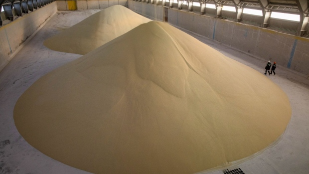 Workers inspect piles of phosphate fertilizer granules in a storage warehouse in Cherepovets, Russia.