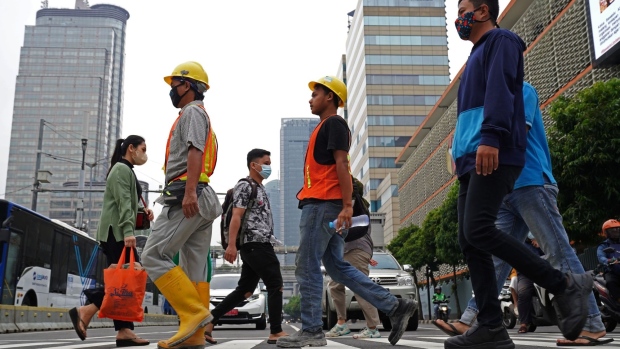 Morning commuters and construction workers at a pedestrian crossing in the central business district of Jakarta, Indonesia, on Friday, Nov. 5, 2021. Indonesia's economy decelerated in the third quarter as harsh lockdowns to contain a record spike in Covid-19 cases outweighed higher commodity prices and trade. Photographer: Dimas Ardian/Bloomberg