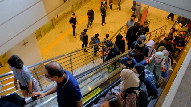 Passengers ride an escalator and climb steps during an event to mark a special RM1 Joyride fare on Express Rail Link Sdn Bhd (ERL) services in KL Sentral station in Kuala Lumpur, Malaysia, on Saturday, Nov. 27, 2021. The 2-day event aims to stimulate local leisure travel and rebuild the public's confidence in using public transportation, while promoting the new KLIA Ekspres mobile application. Photographer: Samsul Said/Bloomberg