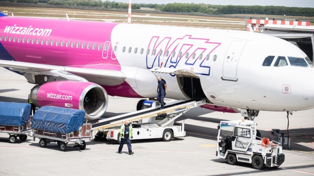 Ground crew prepare to load luggage into the cargo hold of a Wizz Air Holdings Plc passenger aircraft parked at the departure gate at Liszt Ferenc airport in Budapest, Hungary, on Monday, May 25, 2020. Wizz Air is plotting a major expansion at London Gatwick airport as rival carriers pull back, paving the way for the Hungarian low-cost carrier to emerge from the travel downturn with a bigger presence in the world’s busiest city for passenger traffic. Photographer: Akos Stiller/Bloomberg