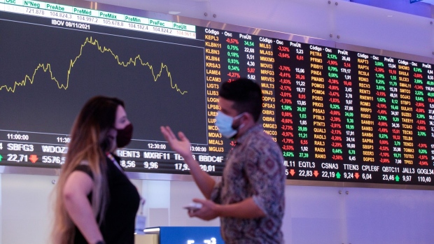 Visitors in front of an electronic board displaying stock activity at the Brasil Bolsa Balcao (B3) stock exchange in Sao Paulo, Brazil, on Monday, Nov. 8, 2021. The Ibovespa opened 0.2 percent lower at 104,627.30 in Sao Paulo, with Brasil Bolsa Balcao contributing the most to the index decline, decreasing 1.9 percent. Photographer: Patricia Monteiro/Bloomberg