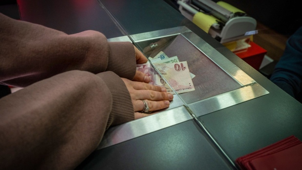 A tourist changes Turkish lira banknotes at the counter of a currency exchange bureau in Istanbul, Turkey, on Monday, March 22, 2021. Turkey's stocks, bonds and the lira tumbled as the shock dismissal of the central bank chief triggered concern the country is headed for a fresh bout of currency turbulence.