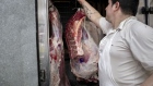 A worker hangs cuts of beef at a butcher's shop in Buenos Aires. Photographer: Erica Canepa/Bloomberg
