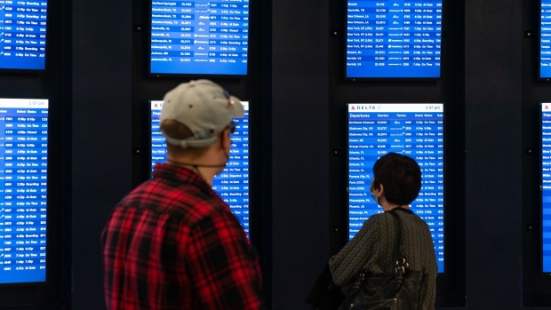 Travelers view departure boards at Hartsfield-Jackson Atlanta International Airport (ATL) in Atlanta, Georgia, U.S., on Monday, Dec. 27, 2021. Flight cancellations that disrupted U.S. travel over the Christmas weekend stretched into Monday, with winter storms further pressuring carriers that were already short-staffed because of spreading Covid-19 cases. Photographer: Elijah Nouvelage/Bloomberg