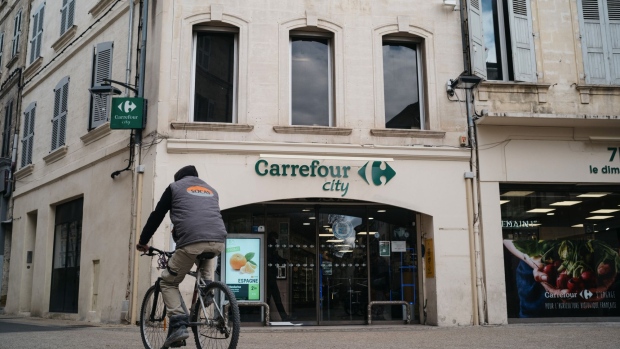 A cyclist passe a Carrefour City supermarket, operated by Carrefour SA, in Avignon, France, on Friday, Jan. 15, 2021. Alimentation Couche-Tard Inc. plans to pump 3 billion euros ($3.6 billion) into Carrefour as the Canadian convenience-store operator seeks to defuse mounting French political concerns over the proposed $20 billion takeover of the French retailer. Photographer: Jeremy Suyker/Bloomberg