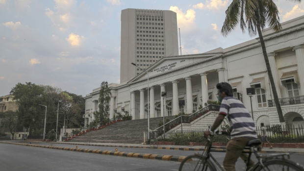 A cyclist wearing a protective mask rides along an empty road past the Reserve Bank of India (RBI) headquarters during a lockdown imposed due to the coronavirus in Mumbai, India, on Wednesday, March 25, 2020. India imposed a three-week long nationwide lockdown for its 1.3 billion people, the most far-reaching measure undertaken by any government to curb the spread of the coronavirus pandemic. Photographer: Dhiraj Singh/Bloomberg
