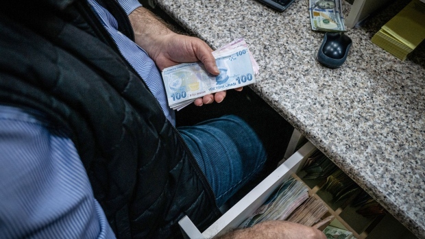 A worker counts out Turkish lira banknotes for a customer at a currency exchange bureau in Istanbul, Turkey, on Monday, March 22, 2021. Turkey's stocks, bonds and the lira tumbled as the shock dismissal of the central bank chief triggered concern the country is headed for a fresh bout of currency turbulence. Photographer: Nicole Tung/Bloomberg