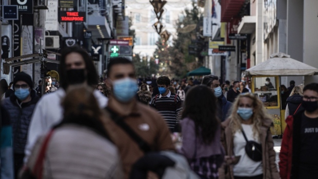 Pedestrians wearing face masks walk along Ermou Street in Athens, Greece, on Tuesday, Jan. 4, 2022. Greece announced new measures to support workers and companies affected by the latest curbs introduced to slow the spread of coronavirus.
