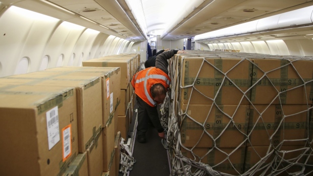 Workers prepare to unload cargo from an Air Canada Airbus A330, a passenger aircraft that has been reconfigured for cargo during the Covid-19 pandemic, at Montreal-Pierre Elliott Trudeau International Airport (YUL) in Montreal, Quebec, Canada, on Monday, Nov. 1, 2021. Air Canada is scheduled to release earnings figures on November 2. Photographer: Christinne Muschi/Bloomberg