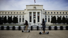 Visitors ride electric scooters near the Marriner S. Eccles Federal Reserve building in Washington, D.C., U.S., on Saturday, Nov. 20, 2021. The Federal Reserve looks on course to consider a more rapid drawdown of its mammoth bond-buying program just weeks after it instituted a plan to scale the purchases back in a methodical manner.