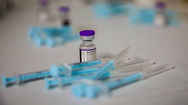 A vial and prepared doses of the Pfizer-BioNTech Covid-19 vaccine at the Grassy Park civic center in Cape Town, South Africa, on Tuesday, Nov. 30, 2021. South African scientists were last week the first to identify the new variant now known as omicron, and while symptoms have been described as mild, the exact risk from the new strain is still uncertain. Photographer: Dwayne Senior/Bloomberg