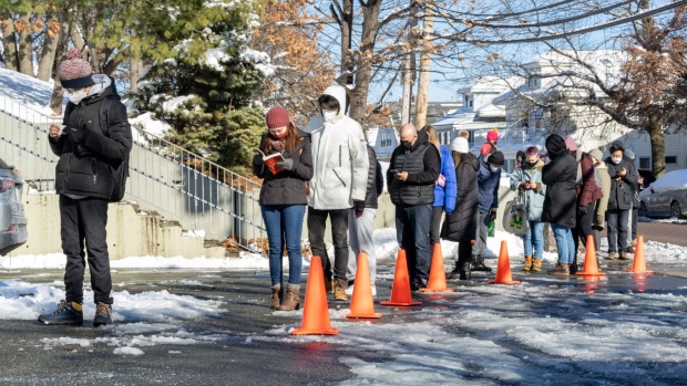 Residents wait in line to receive a Covid-19 test at the West End House Boys & Girls Club in Allston, Massachusetts, U.S., on Saturday, Jan. 8, 2022. The Massachusetts Department of Public Health reported 26,187 new confirmed Covid-19 cases reported, bringing the total to 1,186, 137 total confirmed cases on Monday.