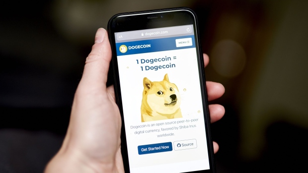 The Dogecoin website on a smartphone arranged in the Brooklyn borough of New York, U.S., on Friday, May 7, 2021. Dogecoin, a cryptocurrency conceived as a joke but now the world's fifth-most valuable, plunged from an all-time high after its most famous cheerleader, Elon Musk, jokingly called it "a hustle" on late-night TV.