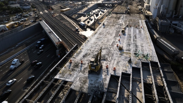 A construction crew works at a site for the Central 70 project at Interstate 70 in Denver, Colorado, U.S., on Thursday, July 15, 2021. Lawmakers have been battling for months to move ahead with an infrastructure package to improve the nation's ailing roads, bridges and transit systems.
