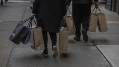 Shoppers carry bags on Fifth Avenue in New York. Photographer: Victor J. Blue/Bloomberg