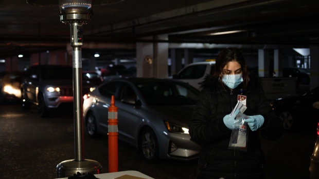 A healthcare worker packages a Covid-19 test for diagnostic testing at a drive-thru site in Southfield, Michigan.
