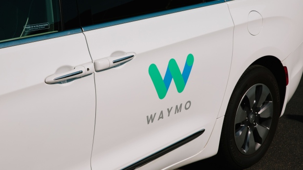 Waymo LLC signage is displayed on the door of a Chrysler Pacifica autonomous vehicle in Chandler, Arizona.