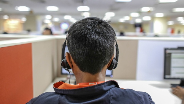 An employee takes a call at a call center servicing Xiaomi Corp. in Bengaluru, India, on Friday, March 31, 2017. Once compared with Apple Inc. for its sleek smartphones and charismatic leadership, Chinese startup Xiaomi is seeking an image makeover as it tries to recover from a sales-growth slide. Photographer: Dhiraj Singh/Bloomberg