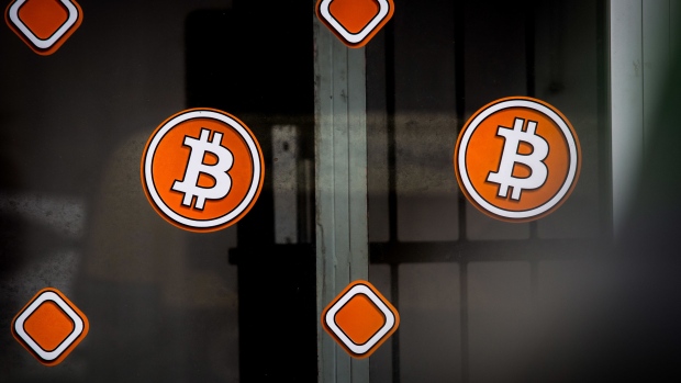 Bitcoin logos in the window of a bitcoin automated teller machine (ATM) kiosk in Barcelona, Spain, on Tuesday, Feb. 23, 2021. Bitcoin climbed, aided by supportive comments from Ark Investment Management’s Cathie Wood and news that Square Inc. boosted its stake in the cryptocurrency. Photographer: Angel Garcia/Bloomberg