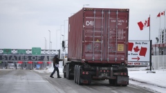 A driver heads back to their truck after stopping at Canadian Customs heading towards the U.S. at the border in St-Bernard-de-Lacolle, Quebec, Canada, on Friday, Jan. 14, 2021. Canada plans to start turning away unvaccinated U.S. truckers at the border this weekend, a move that threatens to upend the flow of everything from food to auto parts to building supplies between two of the world's largest trading partners.