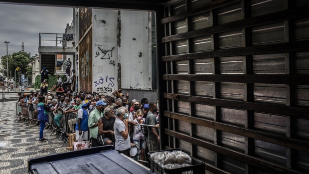 People stand in line to receive food outside the Biblioteca Parque Estadual in downtown Rio de Janeiro, Brazil, on Thursday, April 29, 2021. The Covid-19 pandemic has sent a wave of poverty racing across Latin America, deepening declines that began over the past decade and consigning millions to lives of deprivation.