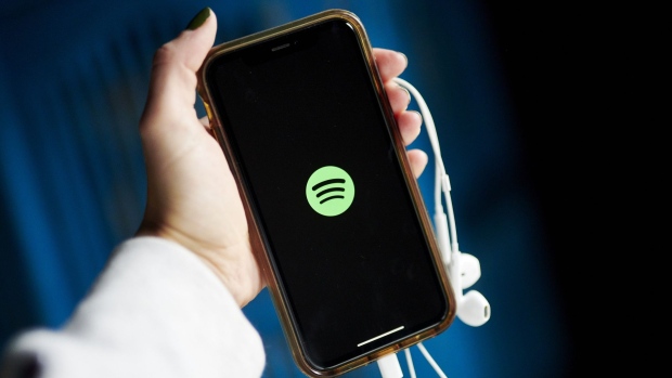 The logo for Spotify is displayed on a smartphone in an arranged photograph taken in Little Falls, New Jersey, U.S., on Wednesday, Oct. 7, 2020. Spotify has invested hundreds of millions of dollars acquiring podcast studios such as Gimlet Media and the Ringer, hoping to attract new users and advertisers to what has been a music app.