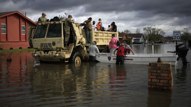 First responders drive a high water vehicle through flooded streets while rescuing residents from floodwater left behind by Hurricane Ida in LaPlace, Louisiana, U.S., on Monday, Aug. 30, 2021. The storm, wielding some of the most powerful winds ever to hit the state, drove a wall of water inland when it thundered ashore Sunday as a Category 4 hurricane and reversed the course of part of the Mississippi River.