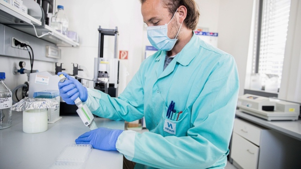A lab technician wearing a protective face mask uses a multichannel pipette dropper during the antigen quantification process of the coronavirus vaccine research at the Valneva laboratories in Vienna.