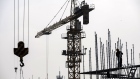 A worker stands next to a crane at a construction site for a residential development on the outskirts of Shanghai, China, on Sunday, March 14, 2021. China’s home prices grew at the fastest pace in six months in February, as a lower supply of projects during a holiday season added to a fear of missing out among buyers. Photographer: Qilai Shen/Bloomberg