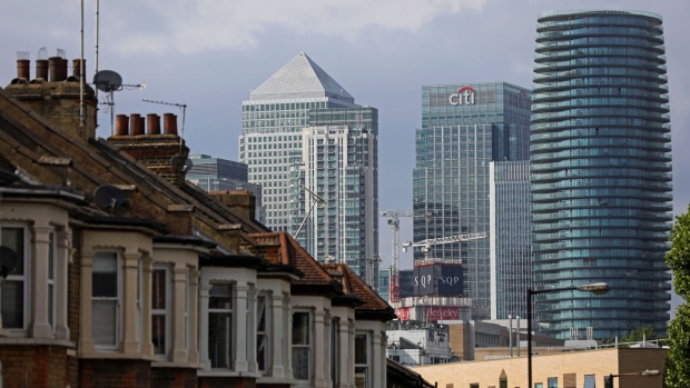 A row of residential houses stand against a backdrop of the offices of Citigroup Inc., right, and the One Canada Square skyscraper in the Canary Wharf business, financial and shopping district in London, U.K., on Thursday, June 5, 2018. The owners of a Canary Wharf skyscraper leased to Citigroup Inc. are seeking to refinance the 661 million-pound ($882 million) loan used to buy it five years ago, two people with knowledge of the plan said.