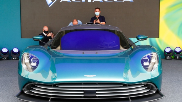 Journalists photograph the Valhalla plug-in hybrid supercar, manufactured by Aston Martin Lagonda Global Holdings Plc, during its reveal event, in Silverstone, U.K., on Thursday, July 15, 2021. The 950-horsepower plug-in hybrid, boasting futuristic lines and a distinct front, will be the middle child of Aston Martin's mid-engine sports car line, priced below the 2.5 million-pound ($3.5 million) Valkyrie and above the Vantage. Photographer: Darren Staples/Bloomberg