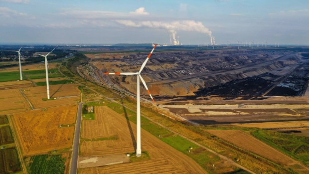 Wind turbines operate beside the Garzweiler lignite mine, operated by RWE AG, in Grevenbroich, Germany, on Wednesday, Aug. 11, 2021. A report from the world’s top climate scientists warned that the planet will warm by 1.5° Celsius in the next two decades without drastic moves to eliminate greenhouse gas pollution.
