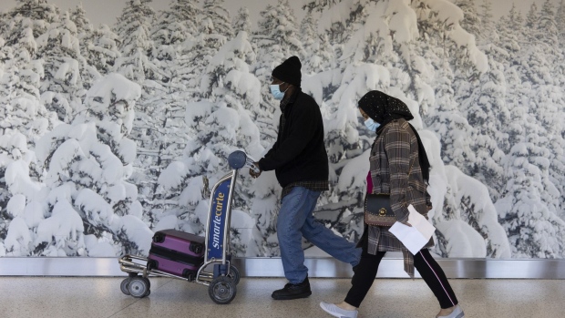 Travelers walk through Terminal 4 at John F. Kennedy International Airport in New York. Photographer: Angus Mordant/Bloomberg