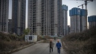 Workers walk near unfinished apartment buildings at the construction site of a China Evergrande Group development in Wuhan, China, on Wednesday, Dec. 22, 2021. Defaulter China Evergrande Group is prioritizing payments to migrant workers and suppliers as regulators demand that the developer head off risk of social unrest.