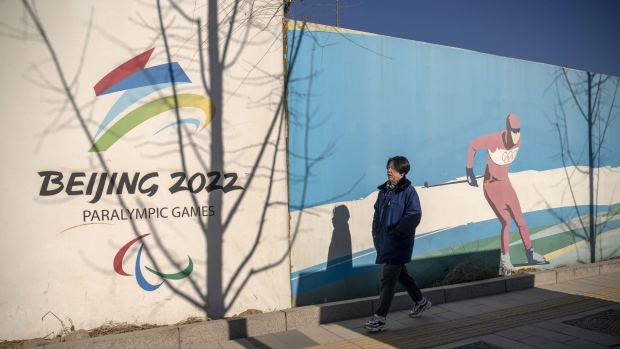 A pedestrian passes a hoarding set up for the Beijing 2022 Winter Olympic and Paralympic Games at Shougang Park in Beijing, China, on Thursday, Jan. 13, 2022. Beijing said it will conduct the winter games in a so-called “closed loop”, with participants only allowed to move between Olympic venues and other related facilities, and to use designated transport services. Photographer: Andrea Verdelli/Bloomberg