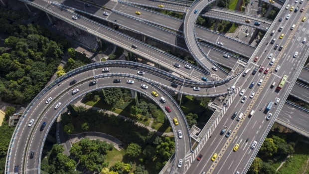 Vehicles travel along an elevated highway interchange above Egongyan Park in this aerial photograph taken in Chongqing, China, on Wednesday, July 29, 2020. China's economy, the first to succumb to the coronavirus, is proving to be the fastest to recover. An industry-powered rebound is pushing the Asian nation out of the historic first-quarter slump and toward being the only major economy to expand this year. Photographer: Qilai Shen/Bloomberg