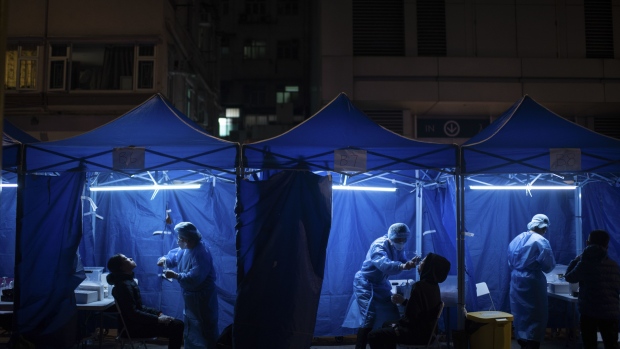 Health workers administer Covid-19 test outside a building placed under lockdown at the City Garden housing estate in the North Point district in Hong Kong, China, on Thursday, Jan. 6, 2022. Hong Kong is imposing strict new virus controlmeasuresfor the first time in almost a year as the highly transmissible omicron variant seeps into the community and threatens to spur a winter wave.