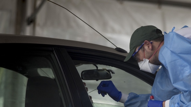A healthcare worker administers a Covid-19 test at a drive-thru testing site in Sydney, Australia, on Thursday, Dec. 16, 2021. Australia’s most-populous state of New South Wales reported a daily record of 1,742 Covid-19 cases Thursday, as the government loosens long-running restrictions ahead of the summer holiday period. Photographer: Brent Lewin/Bloomberg