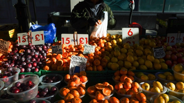A stall holder serves a customer with fresh fruit and vegetables at a market stall in Croydon, Greater London, U.K., on Monday, Jan. 17, 2022. Inflation figures for the U.K., due on Wednesday, are likely to hold steady in December, before peaking in April at around 6.5%. Photographer: Chris Ratcliffe/Bloomberg