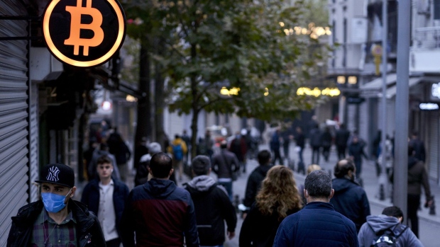 A bitcoin logo sign outside a cryptocurrency exchange kiosk in Istanbul. Photographer: Moe Zoyari/Bloomberg