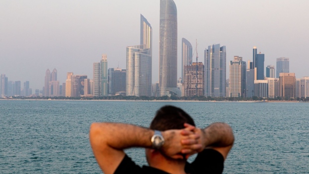 A visitor looks at the view of the city skyline from a breakwater in Abu Dhabi, United Arab Emirates, on Wednesday, Oct. 2, 2019. Abu Dhabi sold $10 billion of bonds in a three-part deal in its first international offering in two years as it takes advantage of relatively low borrowing costs. Photographer: Christopher Pike/Bloomberg