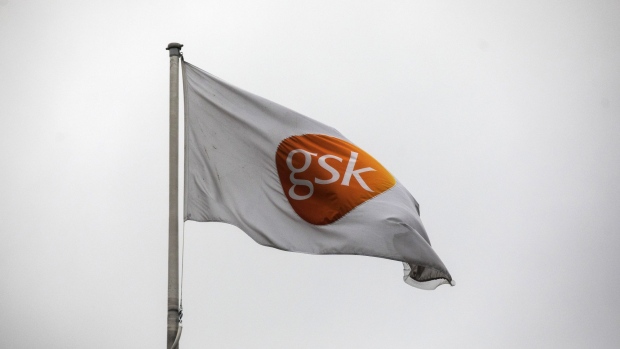 The GSK company flag flies outside the GlaxoSmithkline Plc Research and Development center in Stevenage, U.K., on Tuesday, Nov. 26, 2019. Glaxo is exploring the trillions of microbes that inhabit the gut in pursuit of novel ways to prevent some of the world’s most common ailments. Photographer: Simon Dawson/Bloomberg
