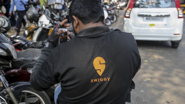 A food delivery rider for Swiggy, operated by Bundl Technologies Pvt., sits on a motorcycle in Mumbai, India, on Monday, Feb. 3, 2020. Indian Prime Minister Narendra Modi’s government plans to allow foreign investors greater access to short-term and long-term government securities in a bid to tap money being poured into passive funds operated by firms such as BlackRock Inc.