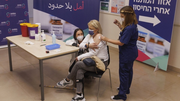 A health worker administers a fourth dose of the Pfizer-BioNTech Covid-19 vaccine to a patient at Sheba medical center, in Ramat Gan, Israel, on Friday, Dec. 31, 2021. Israel’s Health Ministry has approved a fourth dose of the coronavirus vaccine for highly vulnerable populations, a step back from an original plan to administer it to everyone aged 60 and over.