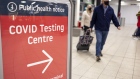 Passengers pass a sign for a coronavirus testing on Monday, Jan. 10, 2022.