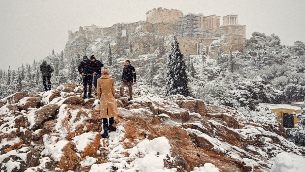 ATHENS, GREECE - JANUARY 24: People take photos of The Parthenon temple atop the Acropolis hill archaeological site during heavy snowfall on January 24, 2022 in Athens, Greece. Heavy snowfall in the Greek capital of Athens has forced authorities to close off sections of highways and many streets. (Photo by Milos Bicanski/Getty Images)
