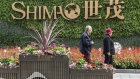 An elderly couple walk past a sign in front of Shimao Tower, developed by Shimao Group Holdings Ltd., in Shanghai, China, on Saturday, Jan. 8, 2022. Shimao, a bellwether for financial contagion in China's embattled property industry, suffered its biggest-ever bond rout on Thursday after a creditor said one of the developers units defaulted on a local loan. Photographer: Qilai Shen/Bloomberg