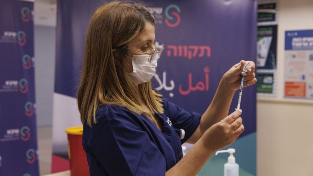 A health worker prepares a fourth dose of the Pfizer-BioNTech Covid-19 vaccine at Sheba medical center, in Ramat Gan, Israel, on Friday, Dec. 31, 2021. Israel’s Health Ministry has approved a fourth dose of the coronavirus vaccine for highly vulnerable populations, a step back from an original plan to administer it to everyone aged 60 and over.